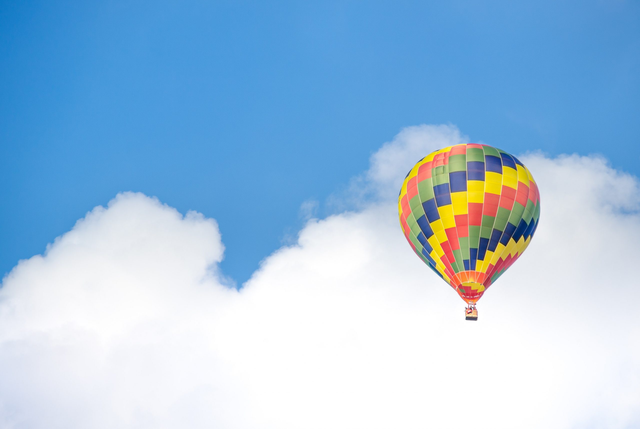 yellow-blue-and-green-hot-air-balloon-flying-near-white-68806
